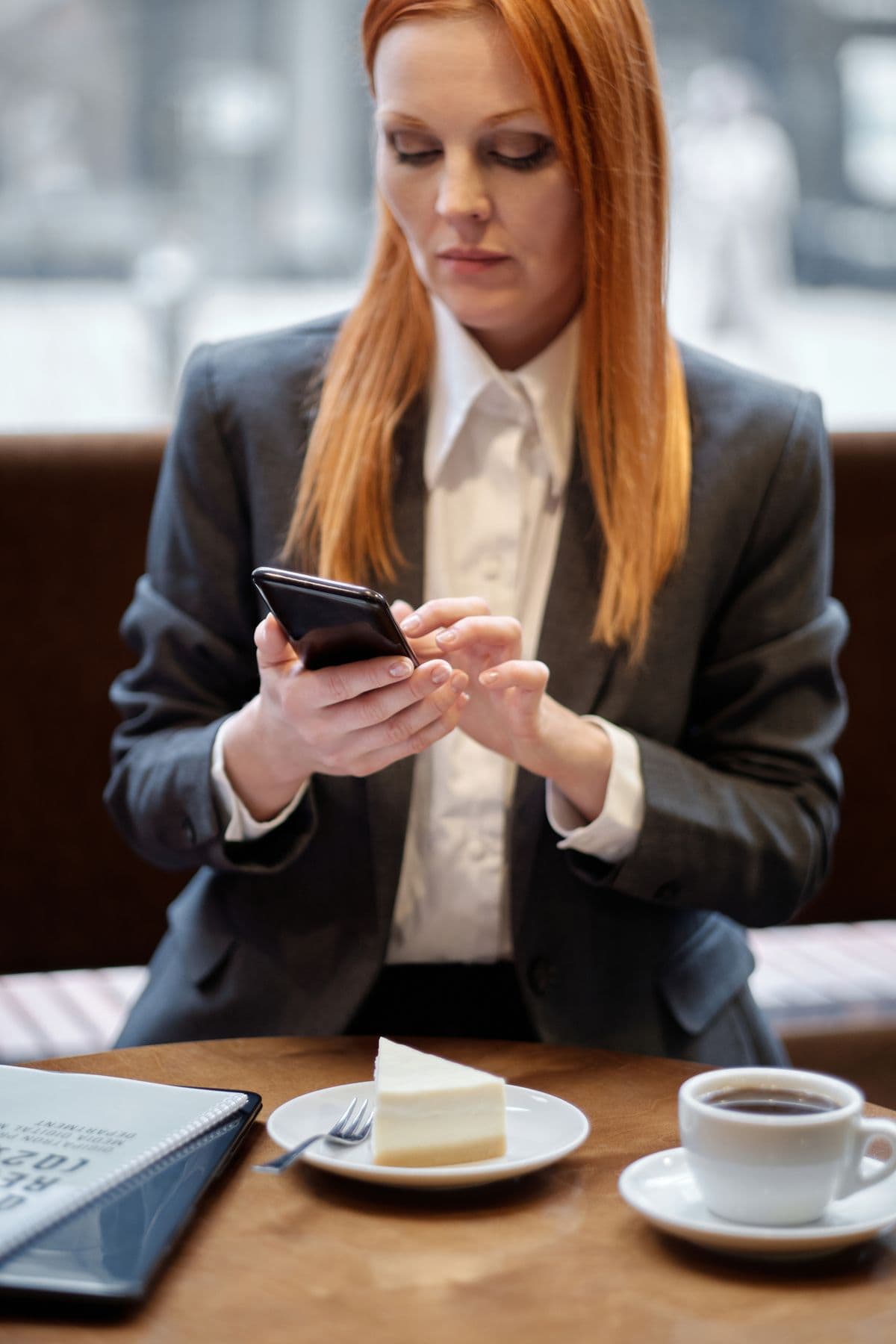 Professionnelle utilisant son téléphone à une table de café